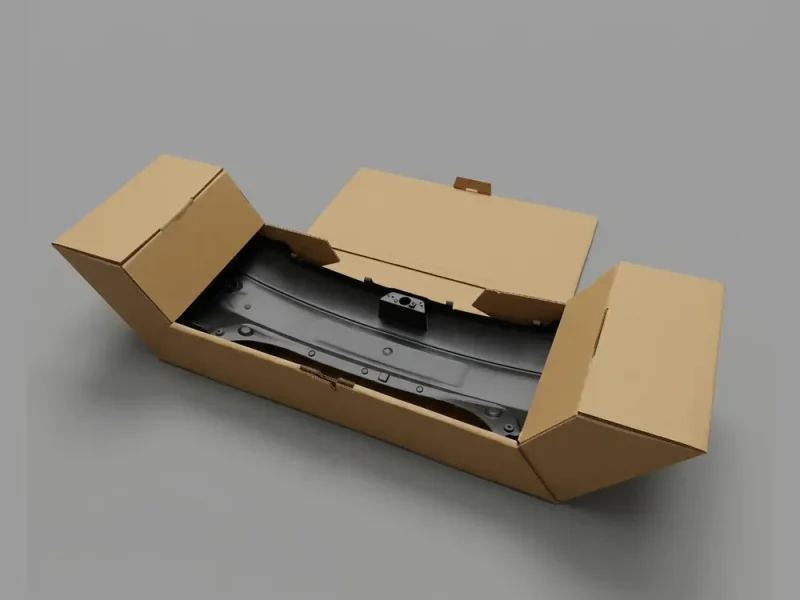 Corrugated shipping box with folding end panels holding a black automotive body part